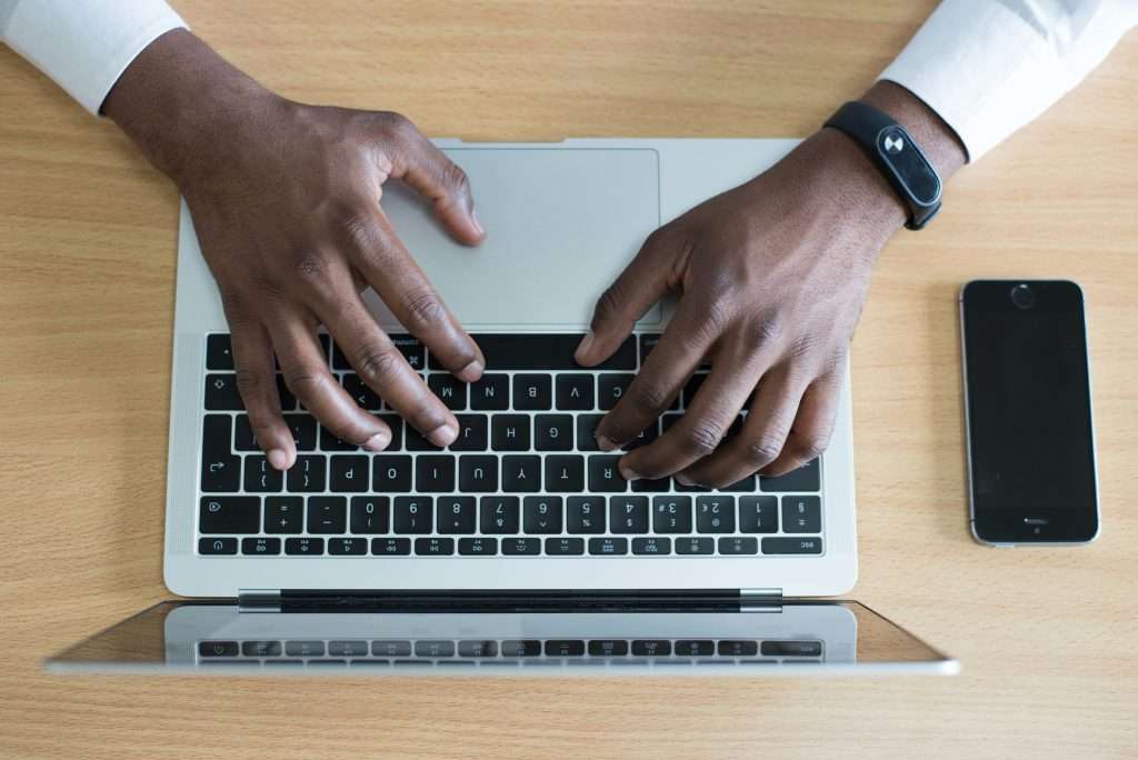 man crafting an email follow up on a laptop